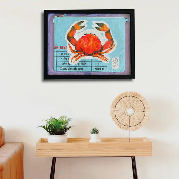 kleine Tasche mit gemalter Krabbe als Kunstwerk eingerahmt an der Wand