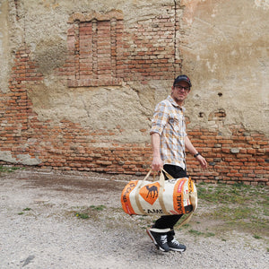 Mann trägt Sporty Bag in beige-orange mit Kamelmotiv auf der Seite