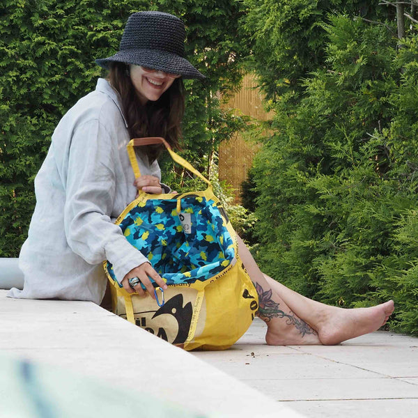 Upcycelter Shopper - Special Edition - in gelb - Frau mit Sonnenhut sitzt damit am Pool