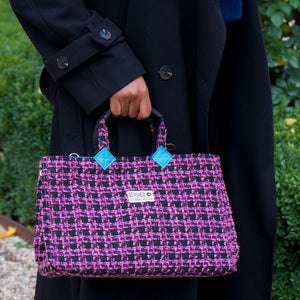 lila-schwarze Isolde Bag wird in der Hand gehalten