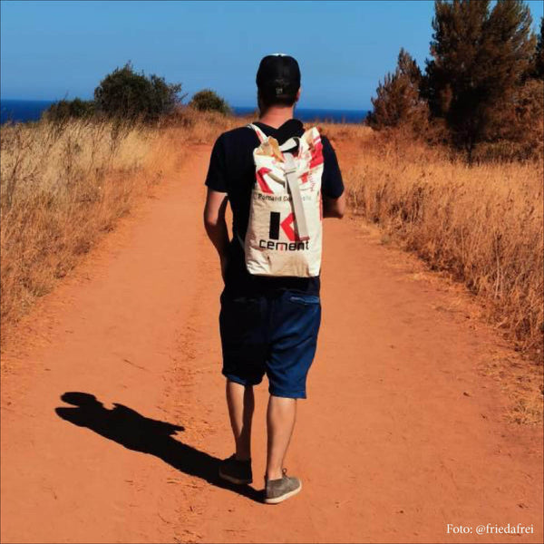 Mann wandert mit Cement Rucksack