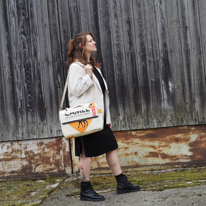 Frau trägt Messenger Bag mit Kamel Motiv lässig über die Schulter gehängt.