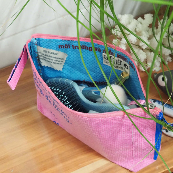 rosa Waschbeutel mit Bürste & Badutensilien gefüllt