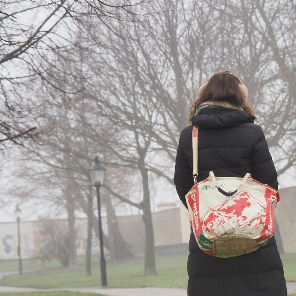 Frau trägt Soulmate ZIP mit Bergmotiv in beige-rot und geht im Nebel spazieren