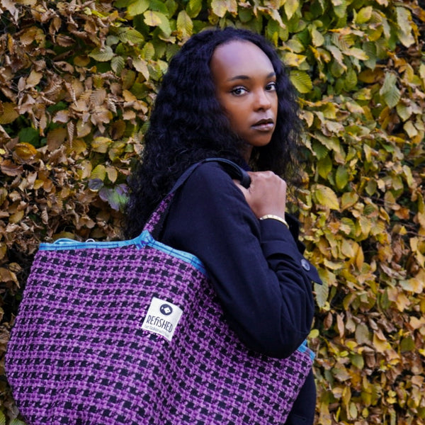 junge Frau trägt lila-schwarze Soulmate TWEED lässig um die Schulter