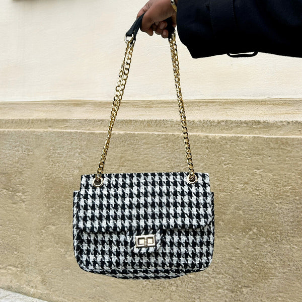 FLAP Bag in schwarz-weißem Tweed wird mit der Hand hoch gehalten