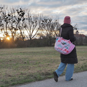 Frau geht mit rosa Soulmate Shopper bei Sonnenuntergang spazieren