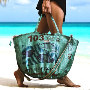 upcycelte Special Edition mit Reißverschluss und Tragegurt in grün - Frau trägt Tasche über den Strand