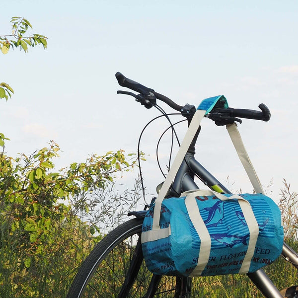 Die upcycelte Sporty Bag in blau hängt an einem Fahrradlenker.
