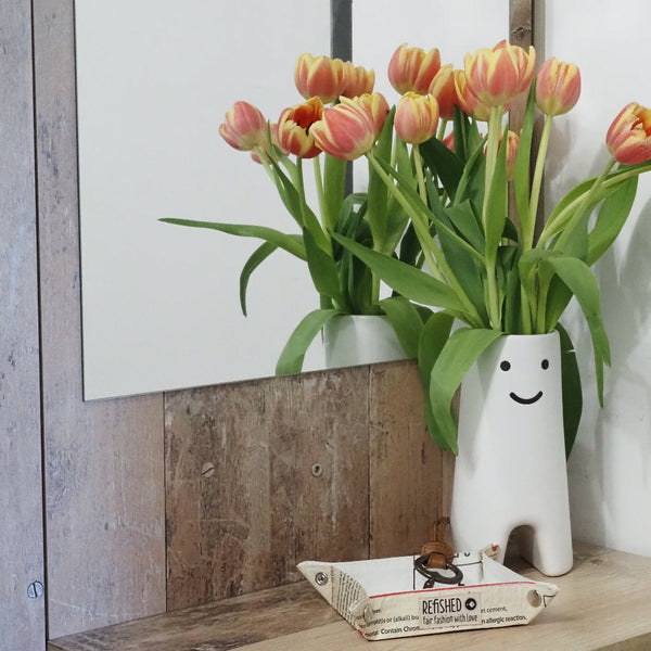 Vide Poche in beige - Taschenleerer im Vorzimmer für Schlüssel neben einer Blumenvase